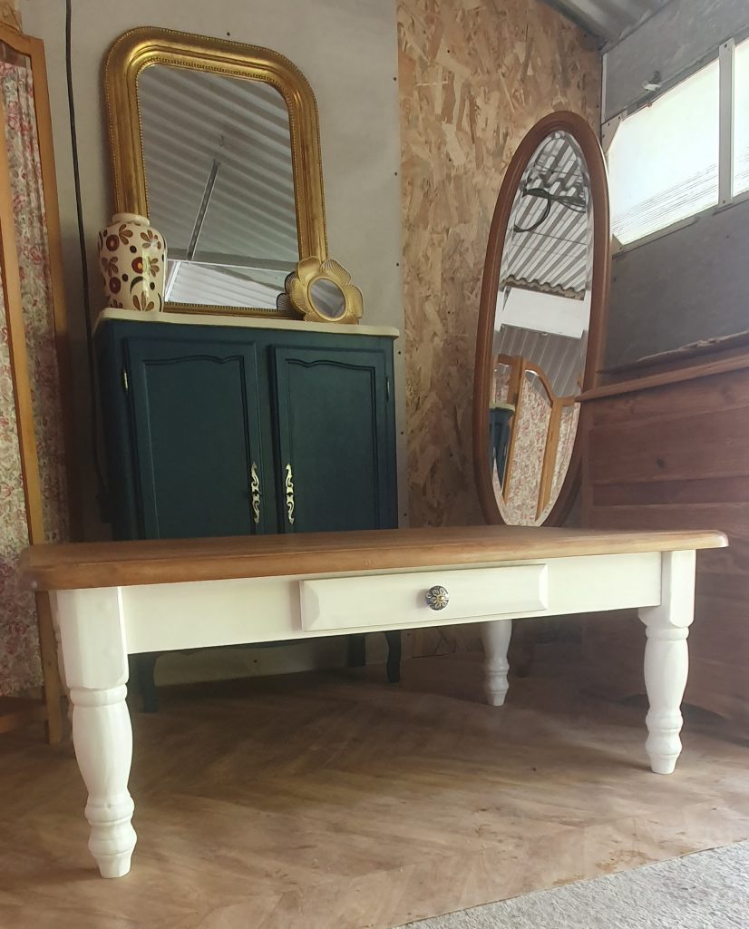 table basse en pin relookée. 1 tiroir retapissé et piétement repeint dans une couleur naturelle. plateau protégé par fondur et vernis mat incolore.