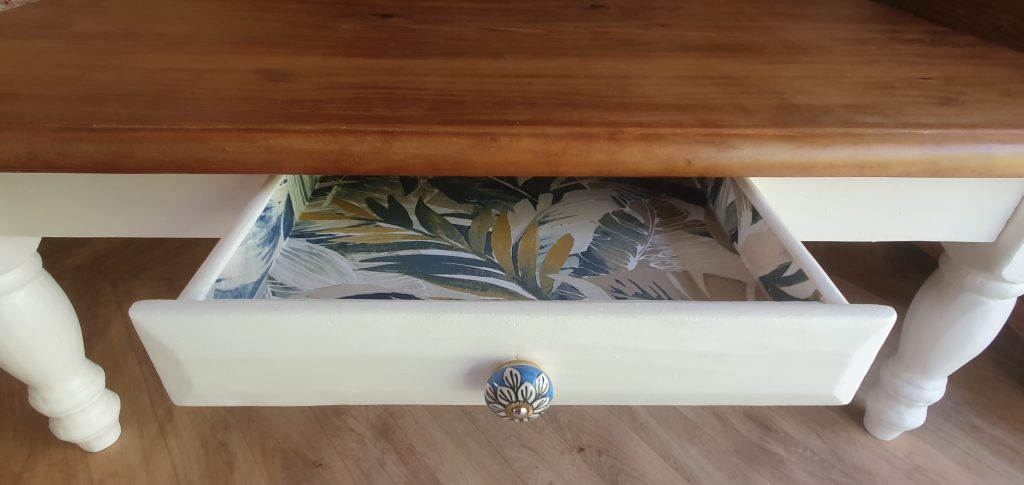 table basse en pin relookée. 1 tiroir retapissé et piétement repeint dans une couleur naturelle. plateau protégé par fondur et vernis mat incolore.