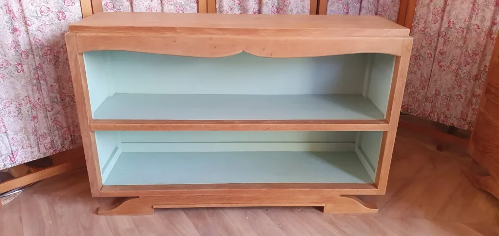 Buffet long ouvert pied moustache. Fond repeint dans une couleur verte douce. Protégé par un vernis mat incolore.